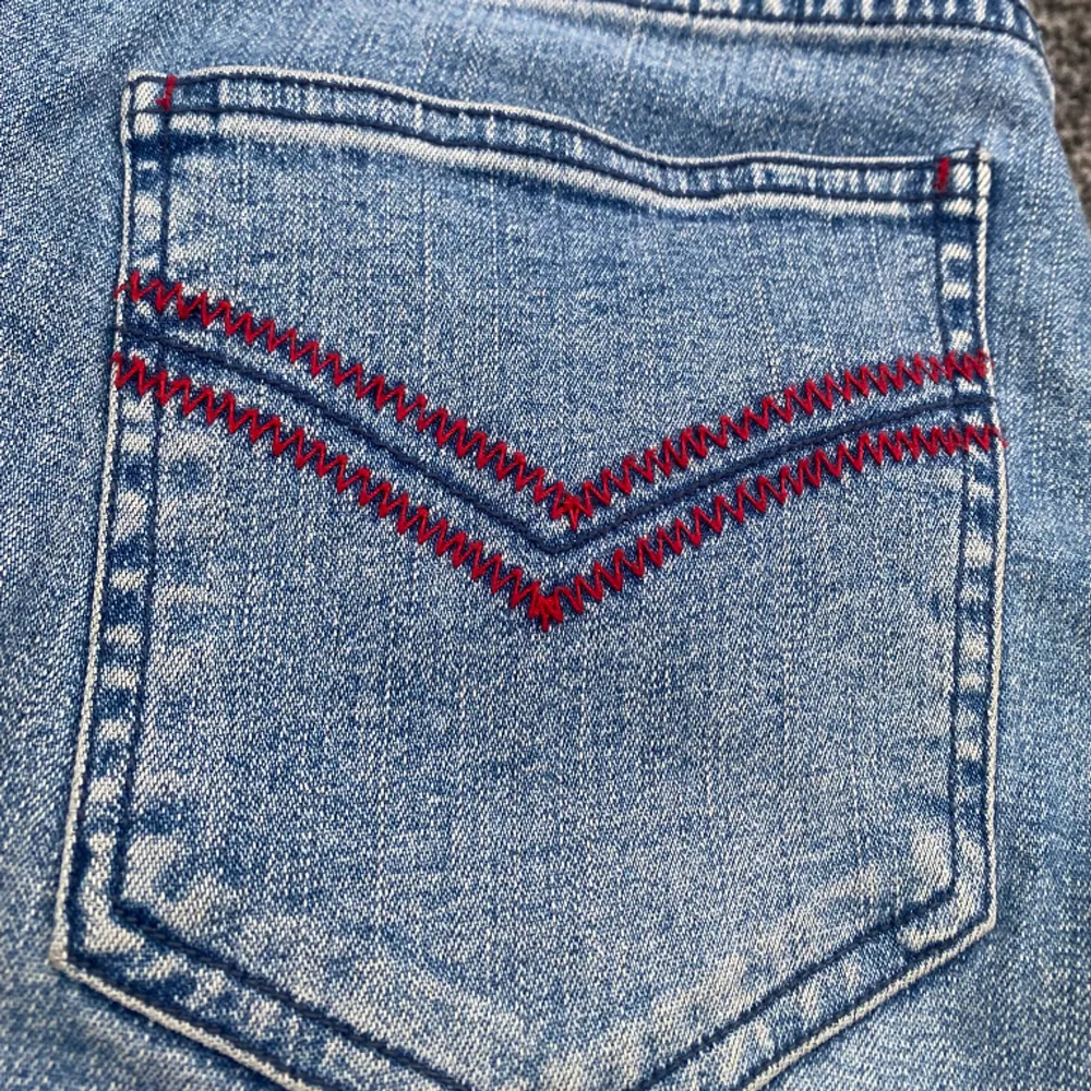 Jätte fina lågmidjade jeans med coola röda detaljer och en snygg ficka vid en av knäna. Beställde hem dessa vintage men de var tyvärr för stora därav säljer jag de vidare❤️ (Startpris 250 kr och om fler är intresserade blir de budgivning). Jeans & Byxor.