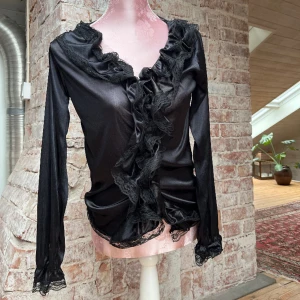 Blus   - Blus med volang och spets🖤går att använda som en kofta, knäpps med knappar.  defekt: en reva på rygg och ärm. Står inte storlek med passar XS-M.