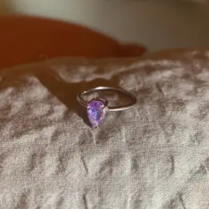 Silver ring med en ”multichrome” lila kristall/glasbit. Säljer åt en vän som inte ville ha den! Nypris: 130kr