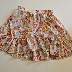 Volangkjol strl 158/164 - Blommig volangkjol i strl 158/164. Resår baktill.