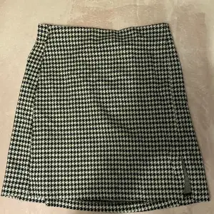 Detta är en kort kjol med svart vit mönster. Inte används mycket, är i väldigt bra skick!