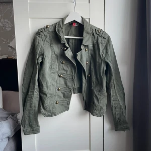 Militärgrän jeansjacka - Jättesnygg vårjacka med coola knappar framtill. Bra skick.
