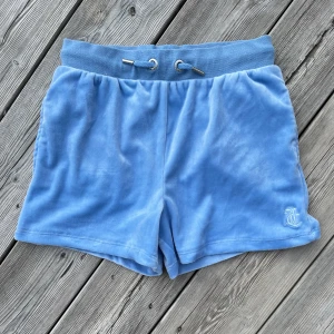 Juicy Couture shorts - - Juicy Couture - short i plysch/sammet - storlek: 10/11y, (funkar även till 12/13 beroende på kropp såklart) - ljusblå - använda 2-3 ggr, nyskick! - tvättad med eko tvättmedel - alltid nytvättat & rollat &nopprat - husdjur i hemmet - rökfritt