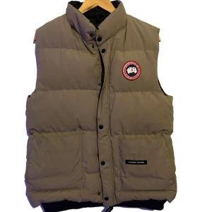 Canada goose väst - Canada goose väst, en fläck (andra bilden), annars fint skick