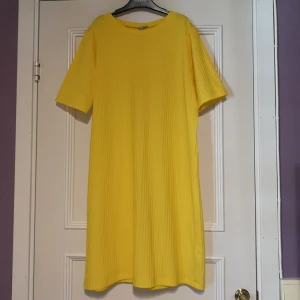 T-shirt klänning  - Citrongul t-shirt klänning i grovt/brett ribbat material. Storlek 38. Går ish till knäna på mig som är 165 cm lång. Bra skick! 