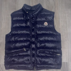 Moncler väst - Säljer min moncler väst som har nfc tag, säljer pga att jag aldrig använder den, står ingen storlek men skulle säga att den passar någon runt 170! Tar även emot byten! KAN GÅ NER I PRIS‼️ 