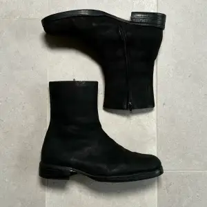 Svarta mocka boots från Martin Margielas AW2001 kollektion. Skick 7/10, använda men utan hål eller allvarligare defekter. Nyligen utbytt vibrant sula. Mockan har fått en speciell textur med åldern men färgen har bättrats på nyligen. 