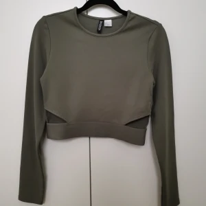 Croptop med cutout  - Topp i oanvänd skick. Toppen är i "tjockt" material, i bra kvalité.