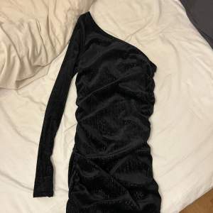 Jag säljer denna fina svarta glittriga sammet off shoulder klänningen som endast är testad.