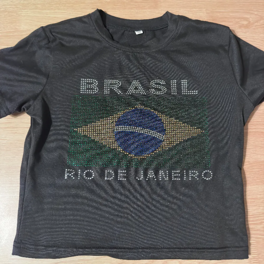 En snygg svart topp med Brazil tryck i rhinestones!. T-shirts.
