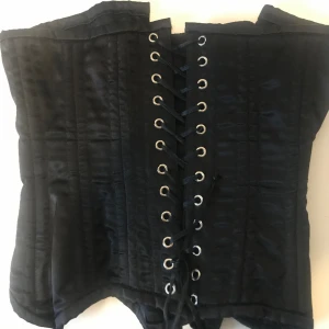 Korsett - Svart korsett man kan bära över eller under brösten, snygg i bra skick- kan fixa bild med den på