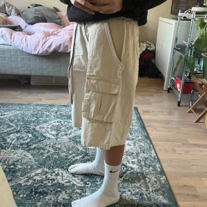 baggy cargo shorts - beigea cargo jorts! väldigt baggy. köpa secondhand men väldigt bra skick. står ingen storlek men skulle säga w32. köparen står för frakt 