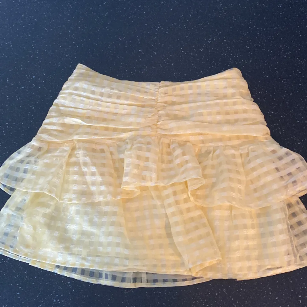 En kort kjol med volanger, jättefin modell till sommaren. Använd 3 gånger Max, jättefint skick. (Säljer då den inte kommit till så mkt användning - har massor av sommarkjolar). Kjolar.