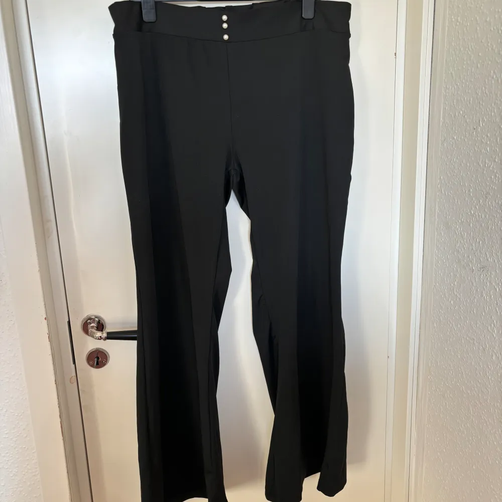 Svarta bootcut/flare leggings med 3 pärlor vid midjan. Jeans & Byxor.