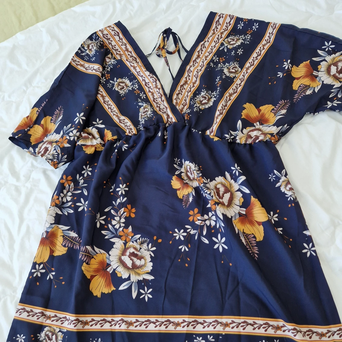 Söt blommig klänning, djup urringning bak.