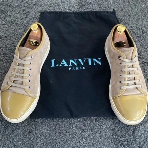Gul/beige Lanvin skor - Säljer dessa feta lanvins i färgen gul och beige. De är i väldigt bra skick och inga defekter finns. De är i storlek 43 men passar även 44. Ny pris är ca 4000kr men jag säljer för 1150 men priset kan diskuteras! Skor och påse ingår👍🏼tvättar de innan
