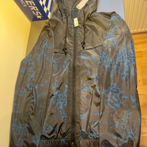 J.Lindeberg Windbreaker - Tjena😇 Jag säljer en helt ny J.Lindeberg windreaker perfekt till lite kallare sommar/vårdagar. Den är i storlek M, tagsen är kvar och den här ett nypris på 4000 kr. Den är väldigt unik och passar på personer som är runt 180 cm och väger 70 kg😇😇 😇