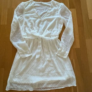 Vit klänning - Säljer denna så fina klänningen som tyvärr inte kommer till användning längre. Jättesöta detaljer! Den är lite genomskinlig så den passar perfekt som en klänning över bikini💓 