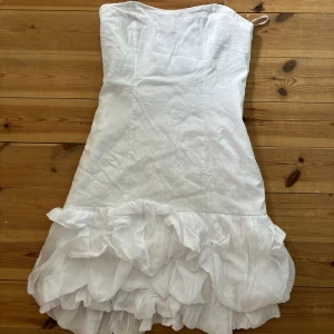 Tubklänning/cocktail klänning  - Söt tubklänning med volang nedtill, vit. Står L men passar även M