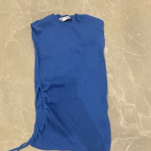 Blå topp från zara  - Oanvänd ny blå ribbad topp/linne från Zara med en split i högra sidan i storlek M.
