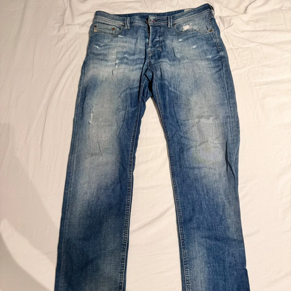 Lite ljusare blå jeans som har hål i sig , original hålen har blivit lite mer slitna än de var från början men det syns inte så mycket sedan är det milt slitage vid muddarna längst då de dragits i golvet. Jeans & Byxor.