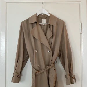 Trenchcoat  - Ljus trenchcoat  med snygga detaljer 