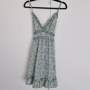 Kort sommarklänning - Jättefin grön sommarklänning med blommor Plagget är i storlek 38 Köpt på second hand men originellt från Shein