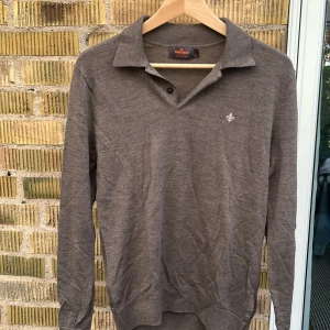 Långärmad polo - Säljer denna långärmade polo från Morris då den blivit för liten. Den är kall brun med mörkare bruna knappar i kragen. Sparsamt använd och perfekt nu till sommar kvällar.