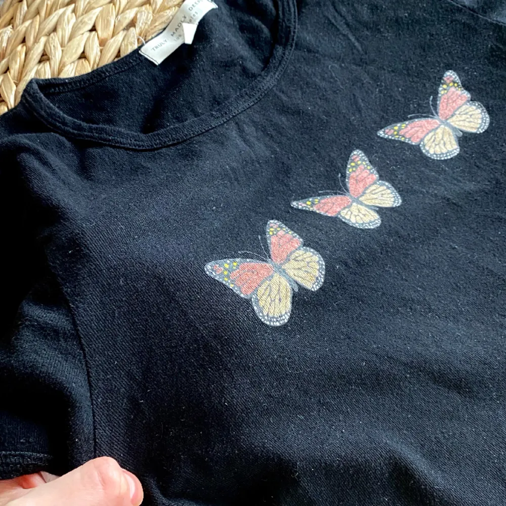 Svart crop top i trikåmaterial med tre fjärilar på 🦋🦋🦋 Väldigt skön. Köpt i Los Angeles. Storlek S, sitter som en S/M.. Toppar.