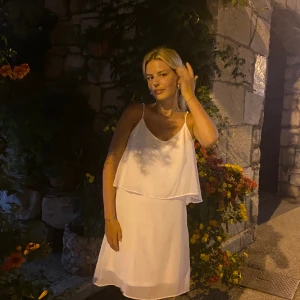 Simpel Studentklänning från Cubus - Jättefin studentklänning ifrån Cubus. Väldigt simpel men har ett lager av volanger upptil. Går att ställa in banden till axlarna. Går ca till knäna.