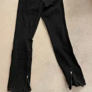 Svarta jeans med dragkedje detalj på baksidan av benet, byxorna har inga defekter. Ord pris 400kr
