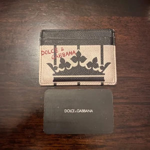 Dolce & Gabbana korthållare - En riktigt fet korthållare från dolce & gabbana som håller mellan ca 5-7 kort och lösa kontanter.  I hyfsat bra skick. Hör av er om frågor och priset är ej hugget i sten.