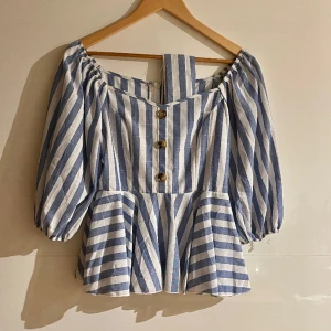 Söt blus! M - En så söt blus som tyvärr inte kommit till användning och bara blivit hängande i garderoben. Ballong/puffärmar och volang vid midjan. Söt på! Strl M. 