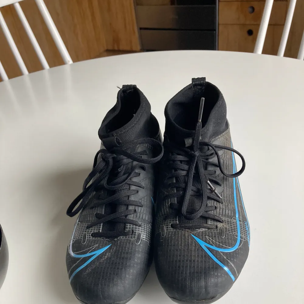 Blå svarta Nike fotbollsskor för gräs och konstgräs. Storlek 35 och väldigt bra skick. Skor.