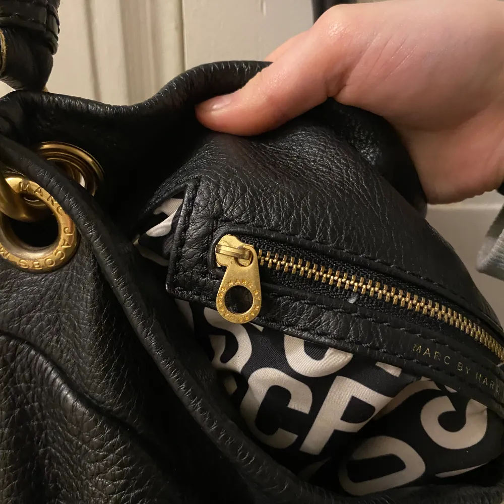 Intressekoll på denna super fina Marc Jacobs väska i svart läder med gulddetaljer🩷 Väskan är köpt på Marc Jacobs för 4500kr och är i super bra skick, förutom en lite läppstifts fläck på ena innerfickan skriv för bild! . Väskor.