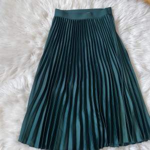 Fin grön veckan kjol som går ner lite längre än vaderna på mig som är ca 165cm Material: 100% polyester  Har små slitage 