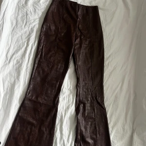 Brun byxa i skinnimitation - Ormmönstrade byxor i brun skinnimitation. Aldrig använda. ASOS 