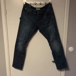 Ganska använda jeans från Jack and Jones. Slim fit med en trasig design.   Storlek: W32 L30