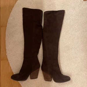 Höga stövlar  - Säljer dessa bruna stövlar med något ljusare brun trä klack i begagnat skick! 
