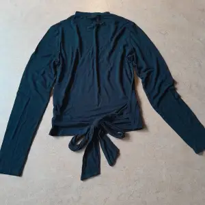 En enkel svart tröja med liten halvpolo - och en väldigt snygg rygg! Storlek M från Lager157. Gott skick!