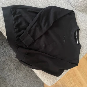 Hugo Boss tröja - En svart Bosströja i mycket bra skick. Endast använd ett fåtal gånger. Funkar som en S eller liten M. 