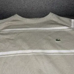 10/10 skick, knappast använd. Mycket fin stickad lacoste sweater. Grå men vita ränder över. Ganska tunn så perfekt nu till sommaren. Pris går att diskutera! (Ursäkta min dåliga Samsung kamera).