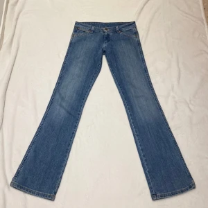 Lågmidjade bootcut jeans - Lågmidjade bootcut jeans från wrangler storlek w26 l32. Midjemått 35,7cm Innerbenslängd 79cm. Kommer inte kunna visa dem på då dem är alldeles försmå. Kolla min profil för liknande💕