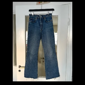 Levi’s jeans - Ribcage Bootcut Jeans i storlek 28. Jag har klippt dem lite nedtill för att jag tycker dem blev snyggare så. Är i perfekt längd för mig som är 165 cm (går ner till hälarna). Tyvärr för stora för mig därav säljer jag dem. I mycket bra skick! Använda max 10