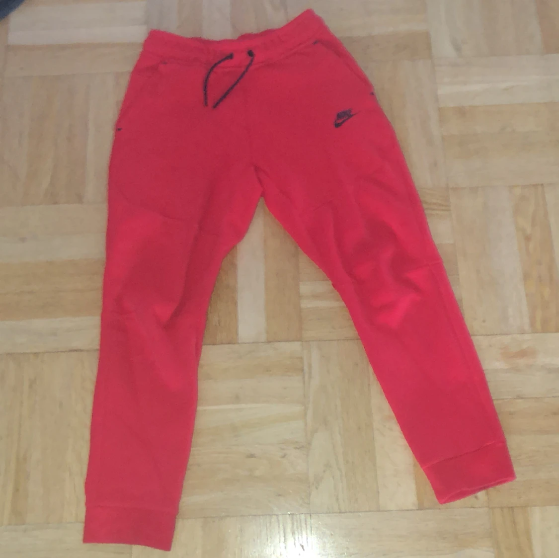 Röda Nike tech byxor 