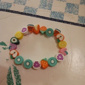 Barnarmband med olika frukter o töjbar tråd . - Barnarmband med olika frukter o töjbar tråd o materialet är lera.Egen design AC .