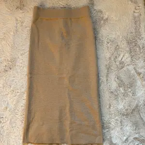 En brun/beige maxi kjol, slutar långt över knäna