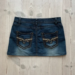 Lågmidjad jeanskjol - Lågmidjad jeanskjol från Honey B blue som jag har sytt upp från en längre kjol. Storlek 36 och det är 38 cm +stretch tvärs över midjan och 31 cm längs med sidan. Fint skick. Använd gärna köp nu!