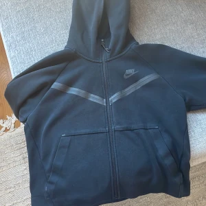Nike tech fleece - En svart Nike tech fleece i dam modell. Skick 7/10, använd välbevarad. Skriv gärna frågor vid funderingar!
