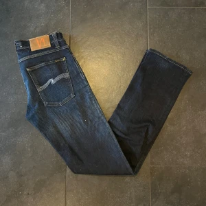 Nudie Jeans - - Märke: Nudie Jeans - Färg: mörkblåa - Storlek: W27 L32 - Skick: Väldigt bra skick, 8/10   Nypris: 1200 Pris: 450kr Om ni är intresserade så skicka bara och frågor!!!